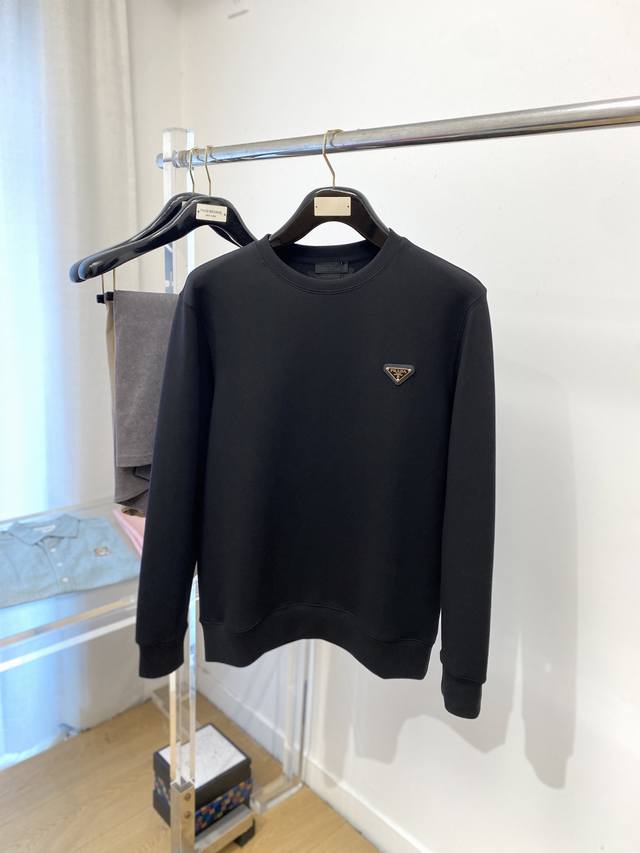 普拉达、2025新品卫衣，帅气时尚，简约百搭款。胸前五金装饰三角标Logo，面料棉 不仅挺括，保持潮流的廓形，又穿着舒适，纱织更细腻，码数M-2Xl