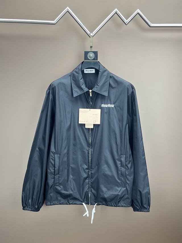 Miumiu尼龙夹克 专柜款正品复刻顶级版本 功能性织物材质： 选用尼龙材质，这种面料具有轻便、耐磨、防水防风等特点，非常适合户外活动或日常穿着。 这款夹克巧妙