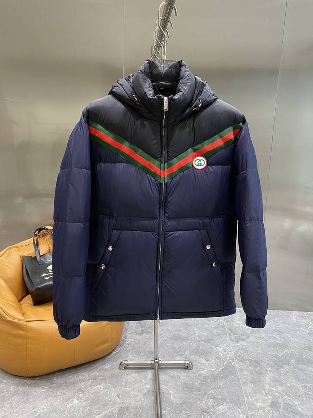 古家 2025Fw新款双G满Logo 这款拉链羽绒服是焕新推出的配饰和成衣系列中的一款 再生尼龙由可回收利用的缝纫线和辅料制成，依托灰色背景突显品牌标志性的Gg