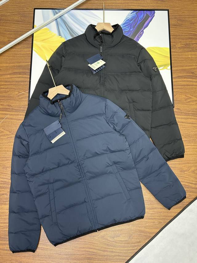 细节 ，普拉达立领款羽绒服prada 普拉达 金属标 再生尼龙 男士加厚保暖羽绒服外套。面料选用客供的再生尼龙，非常符合当下的环保理念。经典的商务休闲风格简约干