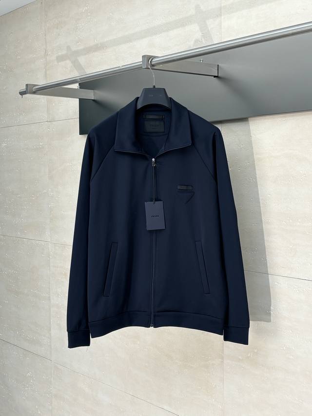 prad* 普拉达 饰织物三角标拉链夹克套装 以80%天然棉纤维为主体，加入少量竹纤维与聚酯纤维等织造而成的健康布面料。棉纤维提供天然的透气性和舒适性，少量聚酯