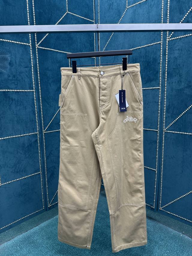 迪奥 25Ss新款工装牛仔裤是二零二五秋季男装系列新品，来自 Dior And Lewis Hamilton 限定系列。采用米色棉质面料精心制作，饰以同色调联名