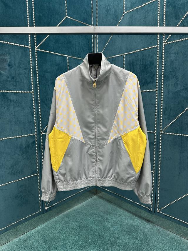 驴家 25Ss新款运动衫以科技面料和 Monogram Glow 印花结构成就生动拼接设计，可搭配同款短裤，延续当季率性旅行风尚。高领、拉链开合、弹力下摆及袖口