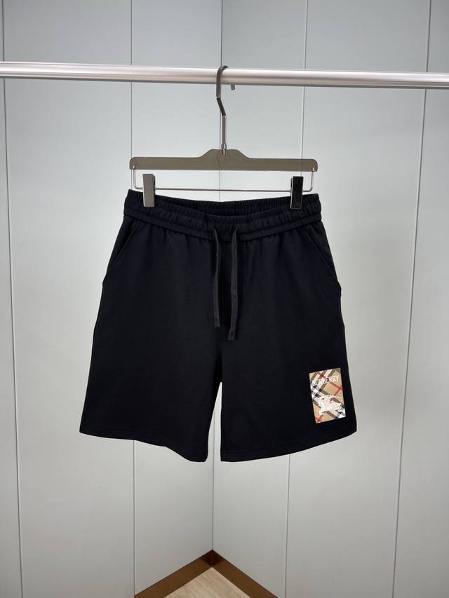 Burberry.巴宝莉 夏季男士新品格纹标签贴花冰氧棉休闲短裤，正面左侧脚口边贴花巧妙融合Burberry格纹马术骑士徽标元素，创意重释品牌标志性设计，弹性松