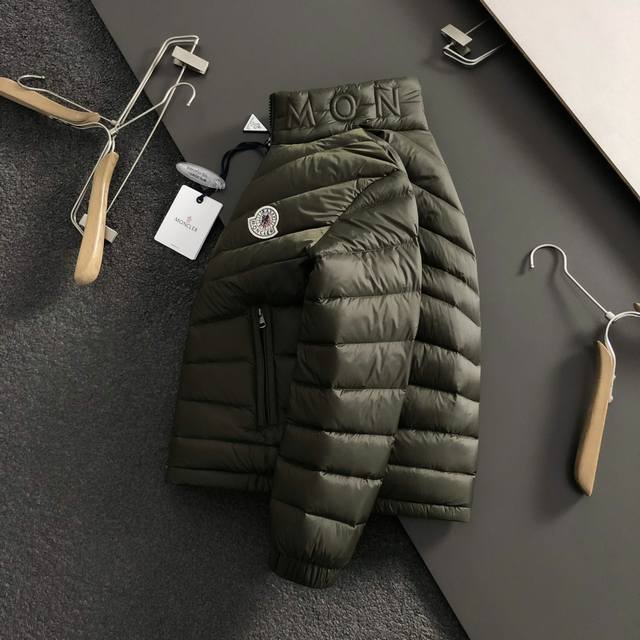 Mon*合身版型48-56 2025秋冬90白鸭绒羽绒外套，以潮流排骨风格领口字母压花元素点缀为主调，融入胸口袖标元素，内里格纹呼应打破传统羽绒的单调感，彰显个