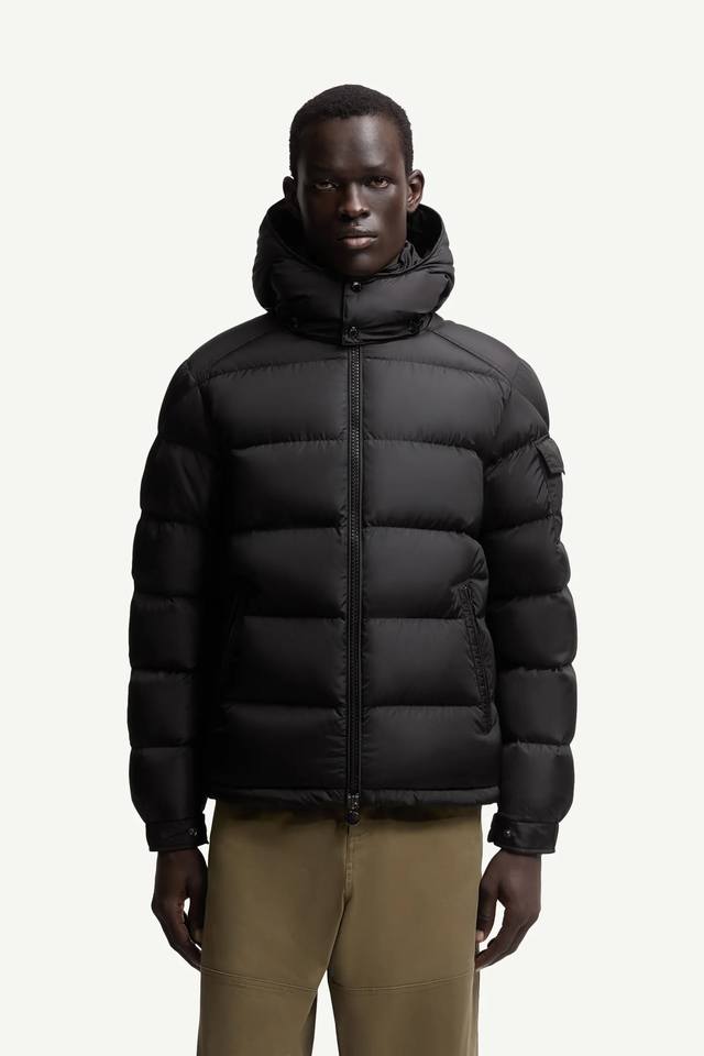 新品Moncler Maya男士羽绒夹克采用柔软的尼龙面料制成，搭配标志性方格块绗缝，彰显Moncler的品牌精髓。此短款羽绒夹克演绎鲜明廓形，配有可拆卸兜帽和