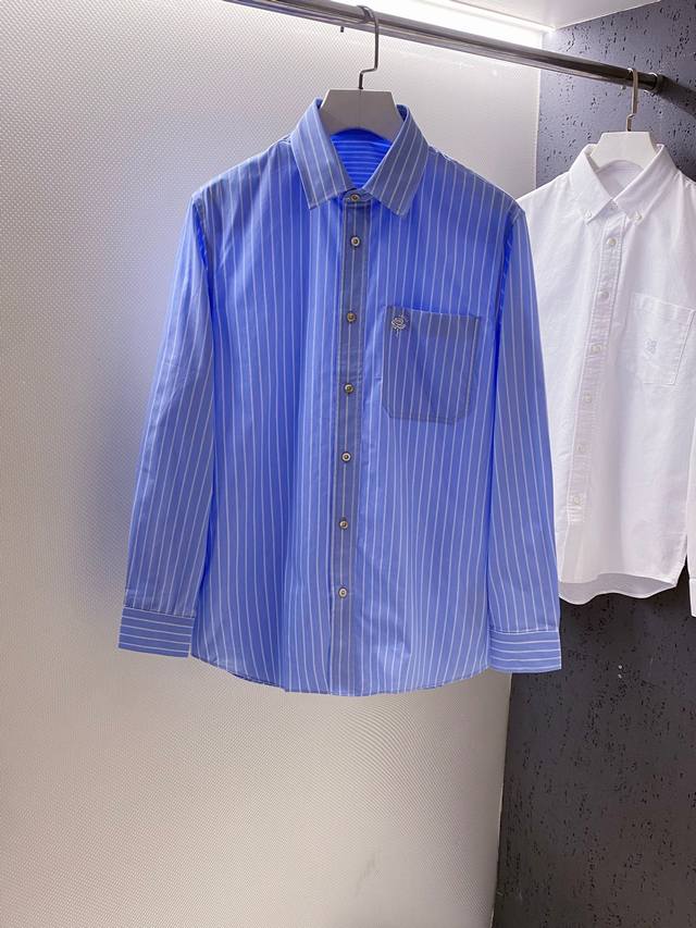 Gu~口袋饰玫瑰花刺绣长袖条纹衬衫 秋季新品 复古经典的竖条纹衬衫，宛如踏入一场永不落幕的时尚盛宴。 面料选用上乘府绸棉、质感挺括又不失柔软，条纹元素复古且经典