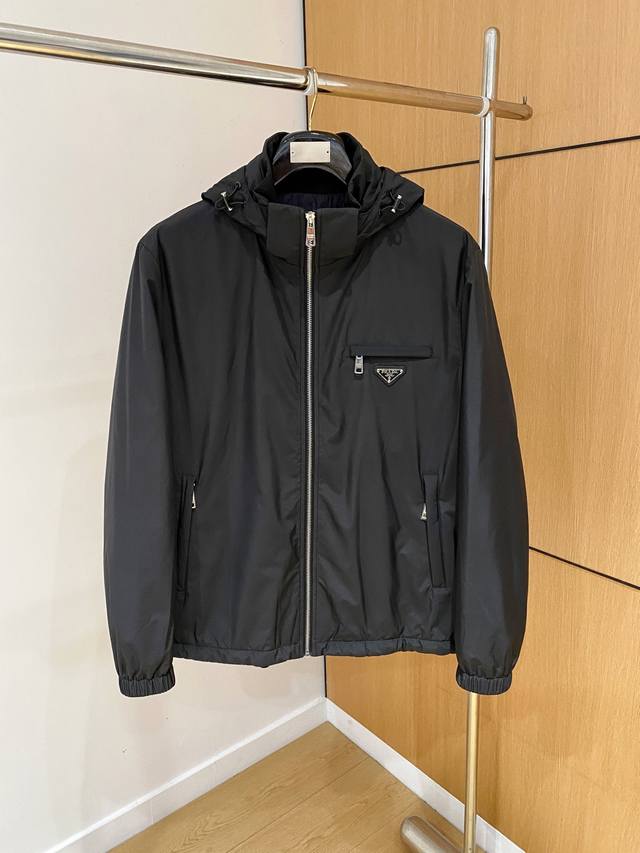 普拉达prada 25Ss秋冬新款商务男士棉服外套时尚休闲夹克，这款普拉达男士外套，是意式工业美学与顶级制衣工艺的结晶。它超越了季节与潮流的界限，以极具辨识度的
