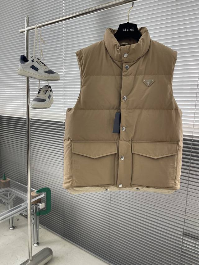 prad 饰三角标羽绒马甲 当意式美学遇见现代运动风，这件pd织物背心便成为你衣橱中不可或缺的高阶单品。它以简约的轮廓承载不凡的质感，立领设计与金属三角形徽标细