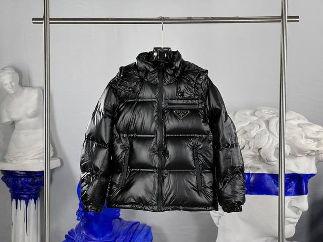 prada 普拉达 经典三角标可拆卸 颜色：黑色 Size：48-56 此款廓形丰满的羽绒采用Linea Rossa独特的双层轻质粘合尼龙面料打造，搭配连帽衣领