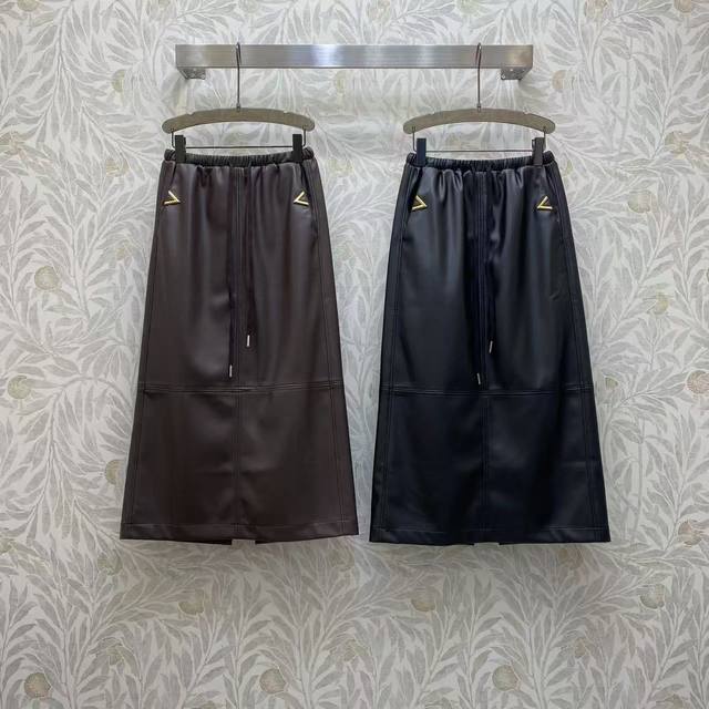 Va★ 2026 Sp 当皮质的酷感遇上金属的精致，这款半身裙尽显摩登格调。金属三角装饰点亮细节，松紧腰设计舒适随性，自带飒爽又时髦的风格。艾颜色:图片2色，面