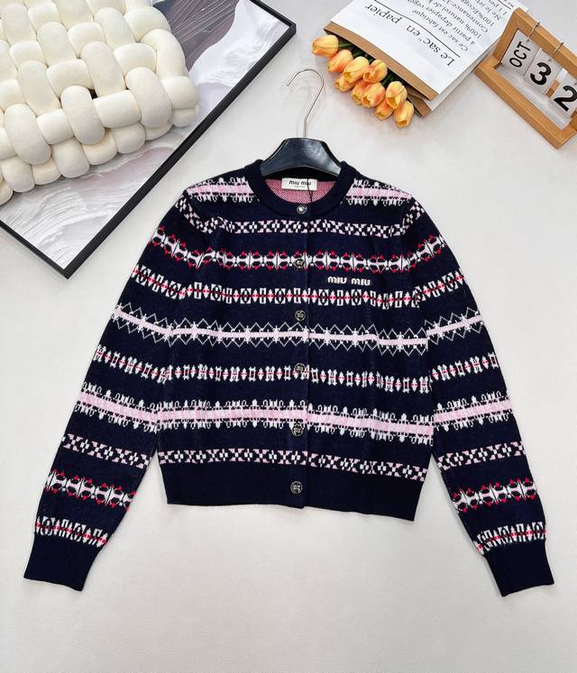 Miu Miu 2025新款复古提花针织开衫，定制的羊毛沙溪，当复古纹样邂逅现代针织工艺，开衫以藏青为底，粉、白、红三色提花交织出满幅艺术感，仿佛将复古美学的画