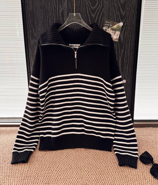 品名：Mium*U新款后背徽标标刺绣半拉链羊毛针织毛衣 尺码：M.L 颜色：条纹 学院风氛围感条纹毛衣，这件条纹拉链针织衫，简约黑白条纹经典不过时，定制Logo