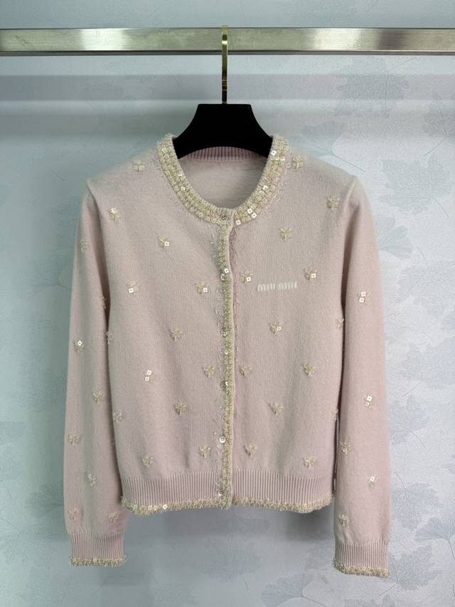Miu*2025秋冬新款钉珠碎花针织长袖开衫！定制羊毛纱线织造，质感细腻，柔软舒适，圆领针织开衫剪裁，领口袖口螺旋纹包边，细致柔软。大身环绕脖子以钉珠点缀，内外