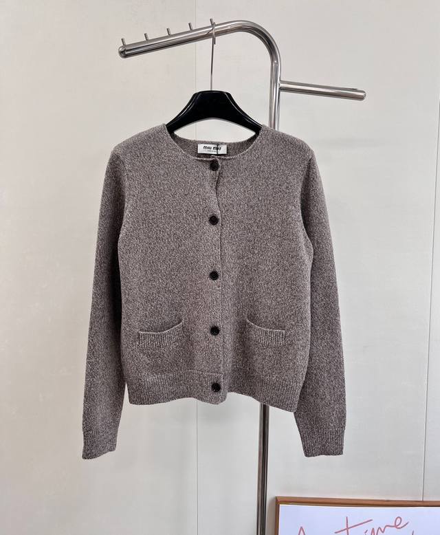 Miumiu2025新款圆领素色针织开衫，定制Yb羊毛纱线织造，质感细腻，穿搭舒适，圆领针织开衫剪裁，大身通体平针素色简约更显腔调，包边以松紧螺纹勾勒收紧，搭配