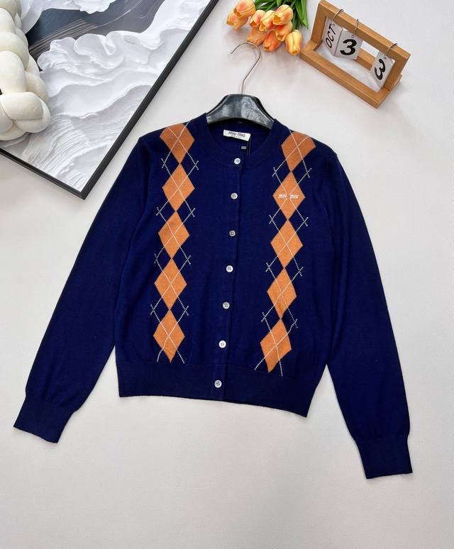 Miumiu2025新款菱格字母针织开衫，定制纱线织造 质感细腻 柔软舒适 圆领长袖针织开衫剪裁 领口袖口螺旋纹包边 细致柔软 大身宝蓝色与胸前对称菱形图案撞色