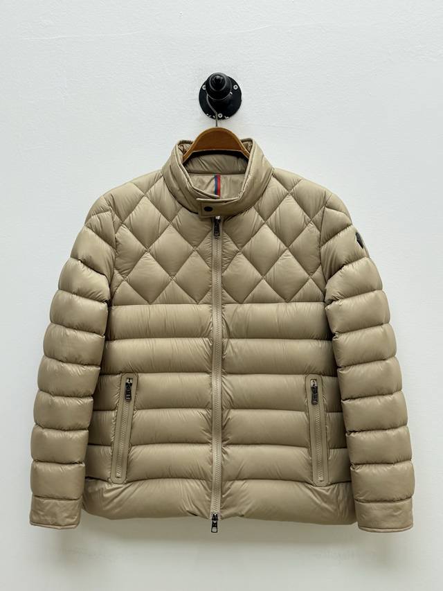 Mon Tuile绗缝立领羽绒服、代工厂p出品 这款夹克选用经典Tuile版型，通过上下不同方向的绗缝塑造立体轮廓，重新诠释都市户外时尚 正面口袋饰以皮革嵌边，