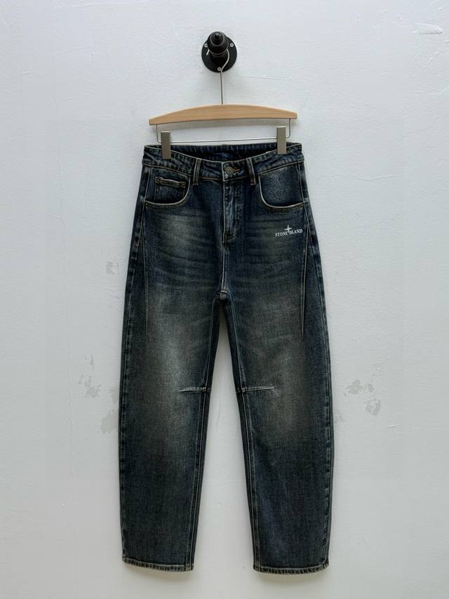 Stone 联名印花装饰弯刀牛仔裤、代工厂p出品 早秋新品 这款牛仔裤选用当下流行的弯刀裤型，铆钉与门襟纽扣采用定制五金，均镌刻精美花纹 正面标识印花，做工精细