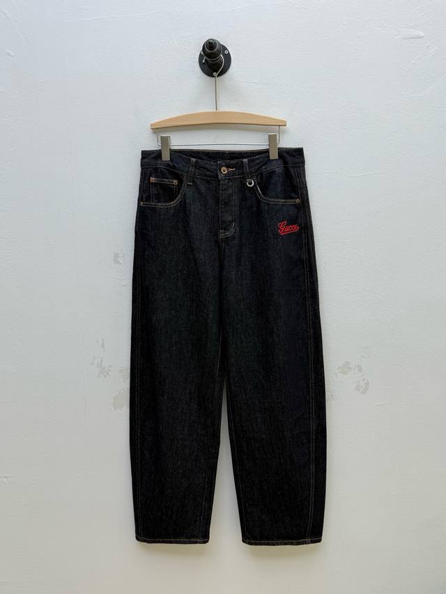 Gu 印花装饰弯刀牛仔裤、代工厂p出品 早秋新品 这款牛仔裤选用当下流行的弯刀裤型，铆钉与门襟纽扣采用定制五金，均镌刻精美花纹 正面标识印花，做工精细，边缘整洁