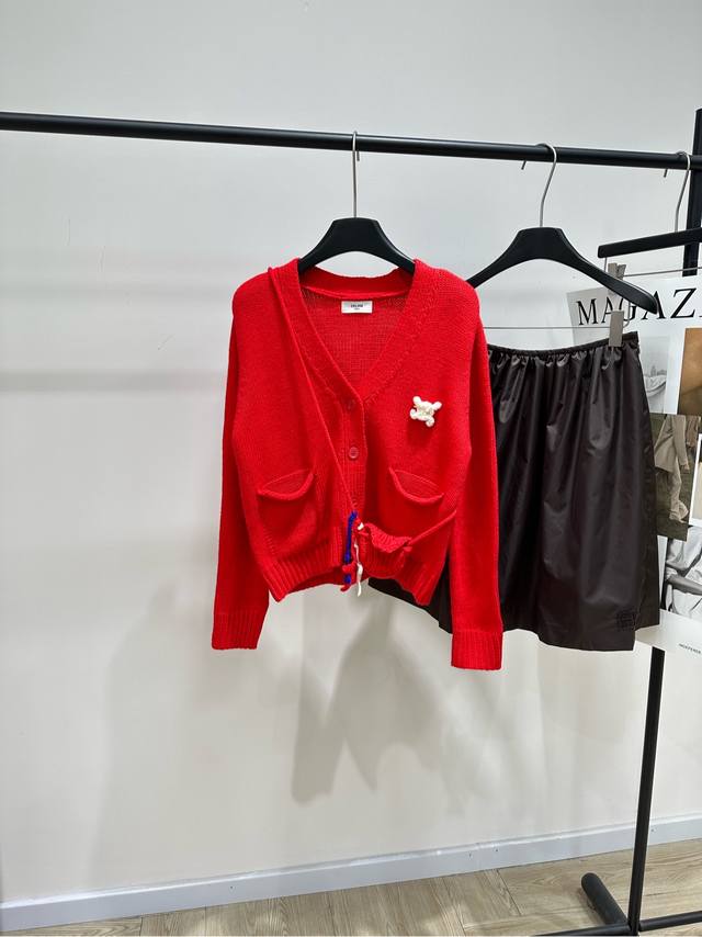 Ce红色别针装饰V领开衫 ，面料：羊毛混纺 颜色：红色 Celine这款针织开衫，柔软细腻 穿着超舒适 V领设计修饰颈部线条 胸前凯旋门胸针假口袋 法式童趣感满