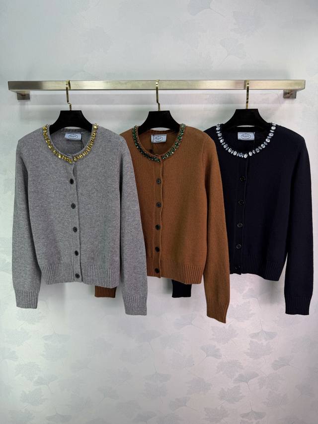 pr*25秋冬新款钉珠圆领针织开衫 采用绵羊毛柔软亲肤又保暖。领口手工钉珠点缀，精致感满满，简约与华丽兼具。版型修身，搭裙装或牛仔裤都很出彩，通勤休闲都能轻松驾