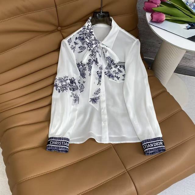 Di2026 Sp 精品真丝衬衣 这款重磅真丝衬衫，白底配蓝调花蝶印花，飘带领+字母袖口设计，质感垂顺柔滑，自带轻奢气质，适配通勤与轻社交场合。 颜色: 黑，白