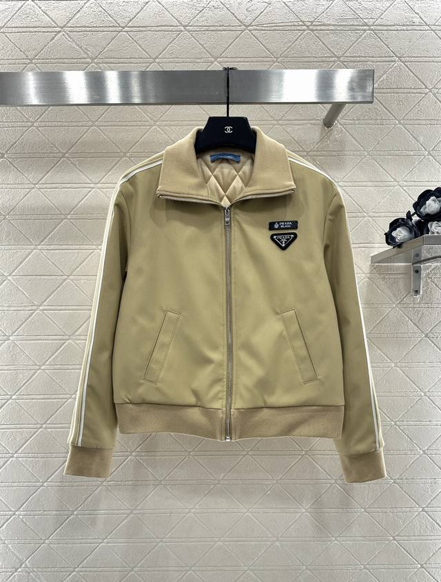 prad*2025新品上架 棉服外套半裙套装 定制Yb进口环保再生尼龙材质，质感光泽，挺括有型，翻领夹克外套中长半裙套装，外套胸前单侧三角徽标点亮细节，两袖条纹