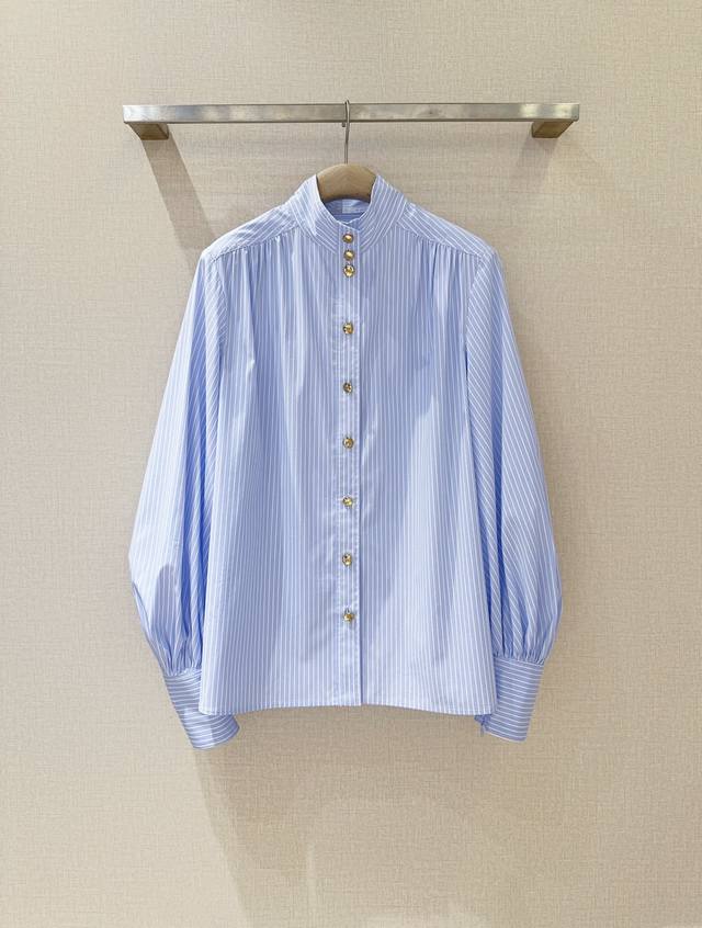 Zimmerm*A*N*N新品上架啦 条纹小高领上衣衬衫女，选用棉质面料制成，采用小高领和宽松长袖，袖口加长设计，带隐形拉链细节，前襟金色纽扣点缀，泡泡袖翩然舒