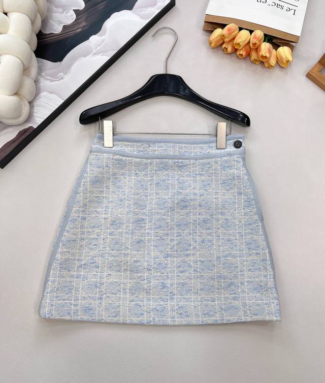 Dior 系列戴妃藤格纹粗花呢西装半裙， 经典重塑，优雅进阶 ，粗花呢混纺面料织就，肌理间藏着细密的米白格纹，自带慵懒的肌理质感；高腰剪裁+微张A字廓形，恰好修