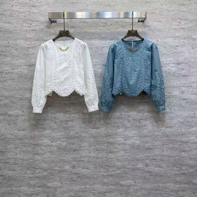 Va2026 Sp 精品上衣 这款精品棉上衣，以精致镂空刺绣为主调，白蓝两色清新雅致，圆领配金属装饰点缀，短款宽松版型显灵动，日常通勤都适配。 颜色:白，蓝 面