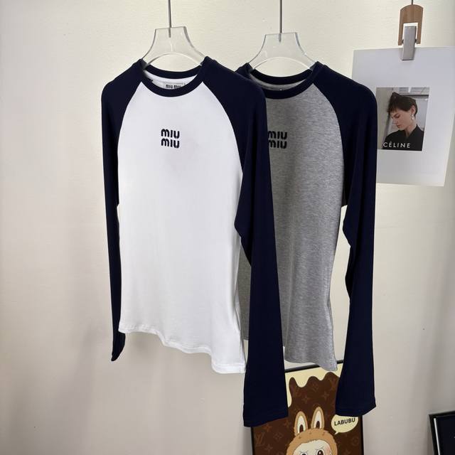 Fw Miu女士修身打底衫，秋冬穿搭的“隐形功臣” 高弹力螺纹针织面料是舒适的底气，贴身不紧绷，活动间满是自在。插肩袖设计藏起肩线小瑕疵，黑白、灰白撞色沿着袖边
