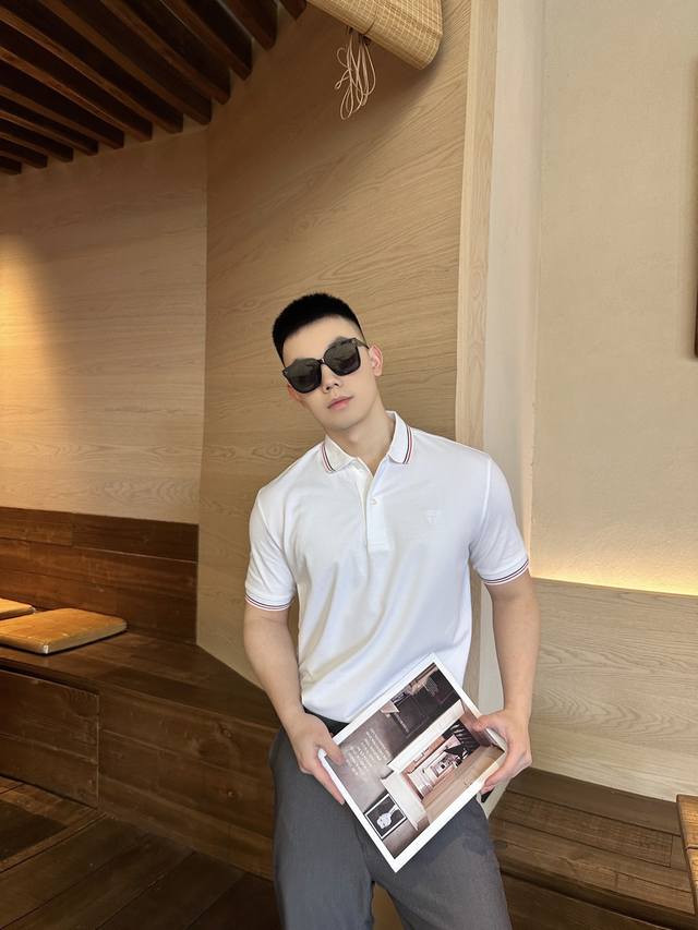 prada 刺绣徽标polo衫 定制雅泽珠光织 透气清爽 舒适贴肤 以白色为主调 黑红条纹巧妙点缀 增添了一抹活力 让简约中不失亮点 标志性prada徽标展现胸