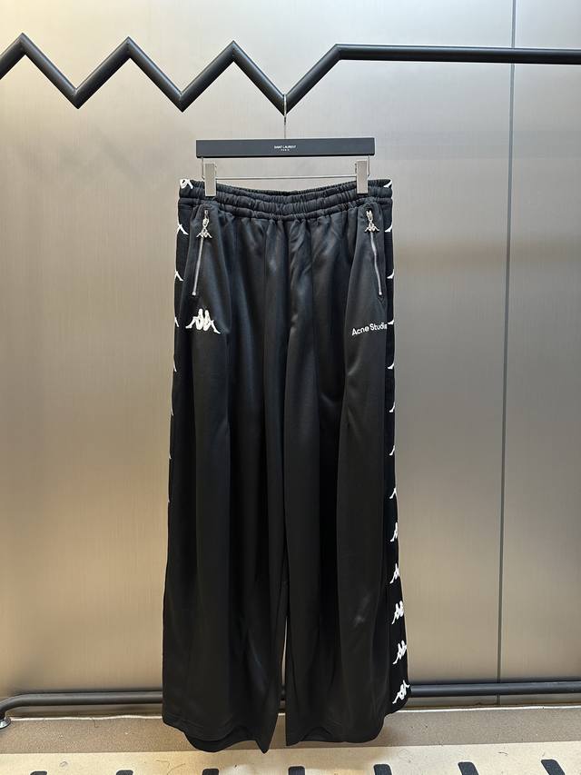 Acne Studios X Kappa 徽标长裤 定制奢光蛋白亚克双面精纺料，标志性Acne Studios标识精巧注脚，邂逅于Kappa经典标识有序排列，经