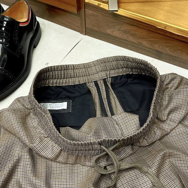 经典色织提花千鸟格100%羊毛简约百搭走秀款松紧腰抽绳设计休闲短裤 经典色织提花千鸟格图案，既具有复古韵味又不失现代感，能够为穿着者增添一份独特的魅力。100%