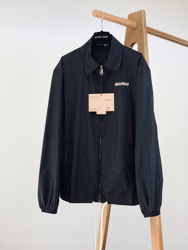 Miumiu 缪缪 字母徽标尼龙外套。 选用尼龙材质，这种面料具有轻便、耐磨、防水防风等特点，非常适合户外活动或日常穿着。 这款巧妙地将运动风格与简洁线条相结合