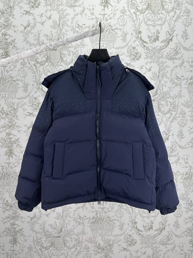 驴家 25Ss新款Monogram 定位图案束腰夹克本款羽绒束腰夹克取材混合面料，可为冬日造型注入经典格调和舒适暖意。可拆卸风帽巧妙衔接衣领，标识硅酮贴饰点缀左