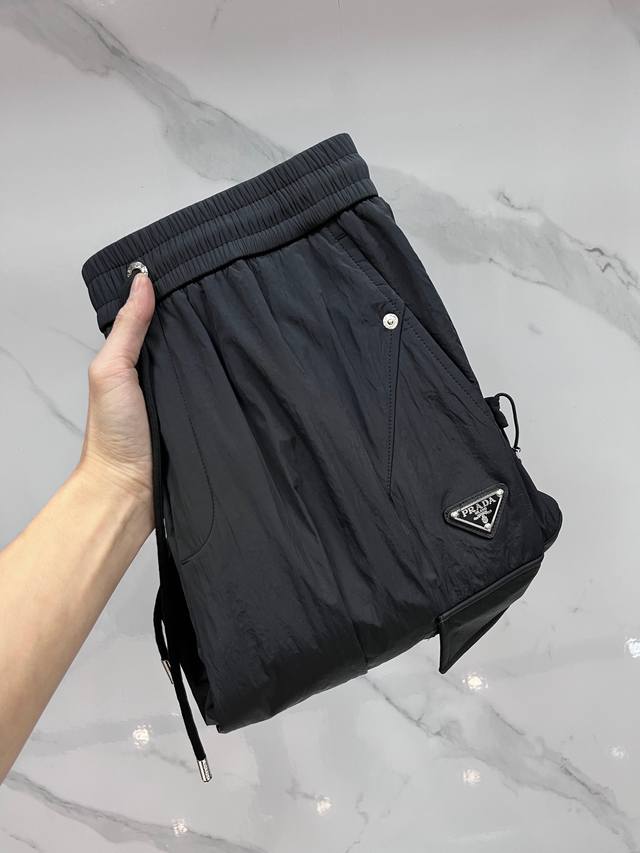 普拉达 25Fw秋冬新款# 防寒机能加厚棉裤# 经典单色长裤柜台在售，防风防雨雪，舒适保暖。直筒收缩脚口裤型，极简设计，双大兜侧袋，运动时尚的同时无惧秋冬严寒。