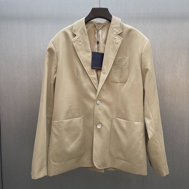 Lu 単排扣都市夹克西装 Size : S-Xl 本款单排扣夹克选用细腻丝棉混纺塑造体闲版型，再以 Lv Crown标识点亮胸袋。平驳领竖起后化身军装衣领，珠光