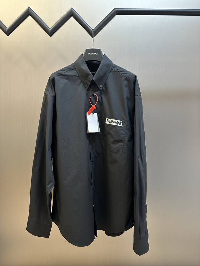 巴黎世家 字母胶带印花衬衫 定制丝光密理府绸布，以经典黑白色调搭配，胸部和背面以Masking Tape芝木作品印花，以不规则的线条和独特的图案像是艺术家随意挥