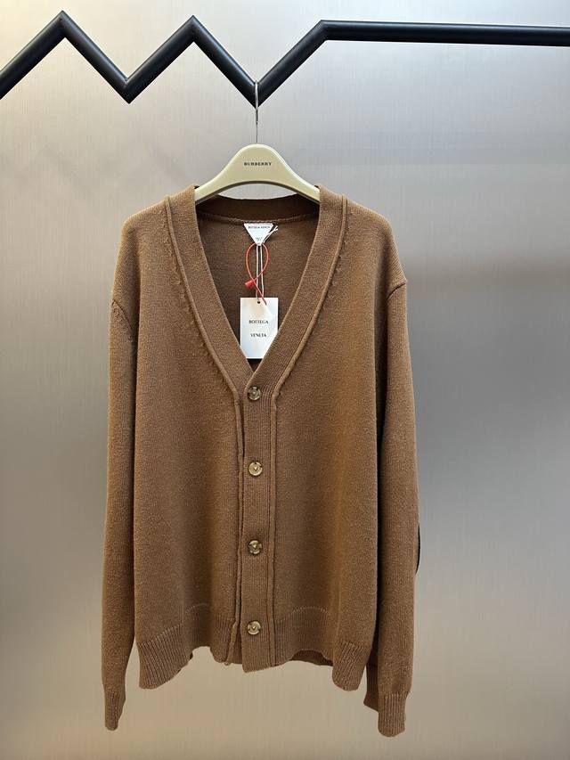 Bottega Veneta 编织皮革毛衣开衫 定制赭金尊纤羊绒纱，色泽饱满。纽扣间距以视觉呼吸感为基础，吸引视线在纽扣的错落间反复游走，融入真皮编织皮革的野性