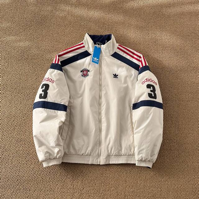 阿迪达斯三叶草秋冬新款双面穿棉服外套 胸前的小巧标志与背面的数字3和Adidas标识相映衬，展现简约而大气！双面设计，无论是纯洁的白色还是深邃的深蓝，都能轻松搭