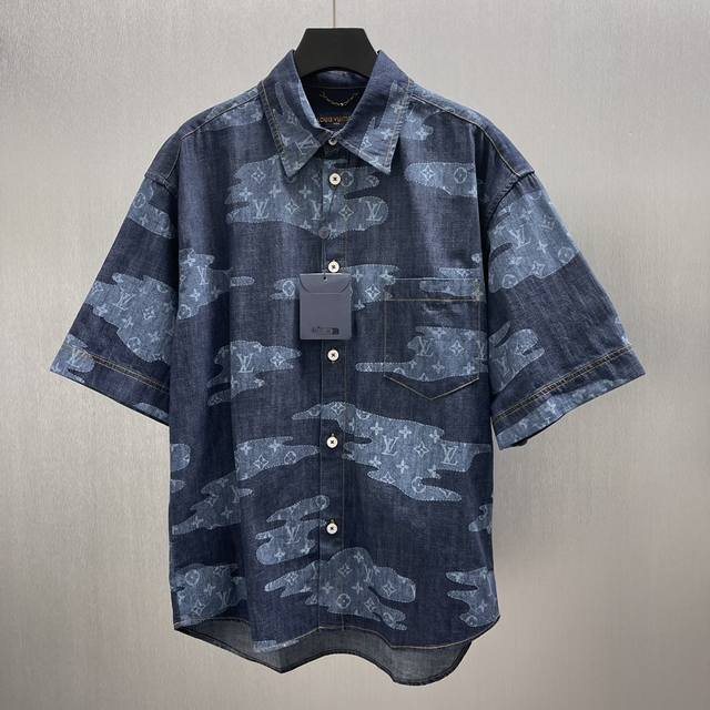 Lu云朵青年布短衬衫 Size : S-Xl 本款青年布短袖衬衫令宛若云朵的 Monogram 贴饰漂浮于深邃背景，，与 2025 秋冬秀场的Monogram