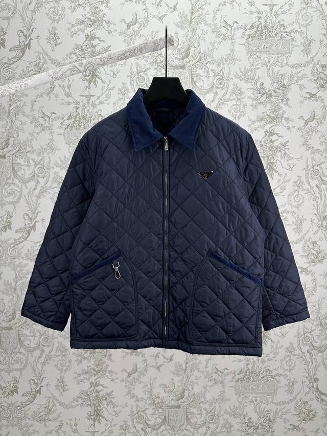 普拉达 25Ss新款再生尼龙短夹克优雅与工艺完美结合：丝绒细节和金属搭扣将这款短夹克转变为具有都市风格的独特服饰。为确保产品的可持续护理，保持其特性并减少对环境