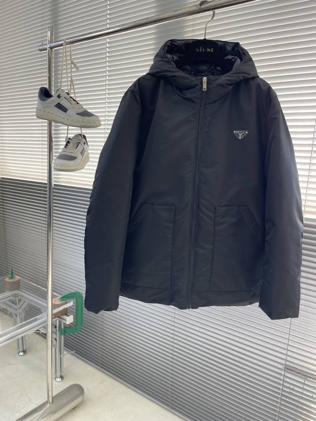 prad 25秋冬新款三角标时尚连帽羽绒服！ 精品稀出，内里填充物以95鸭绒和聚酯纤维为主，均经过严格的挑选工序，其蓬松度与与回弹性都极为优越，御寒性能更是毋庸