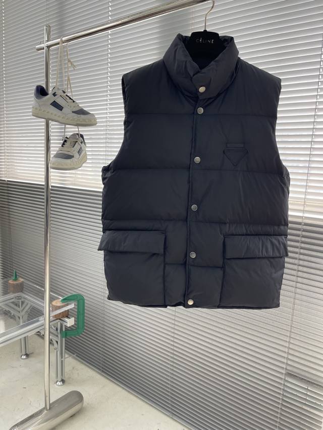 prad 25秋冬新款黑标倒三角标识羽绒背心马甲 定制Yb防风防水尼龙材质 白鹅绒填充内里 整件轻薄保暖 按扣翻盖口袋马甲版型 松紧由人 经典长方格压纹立领设计