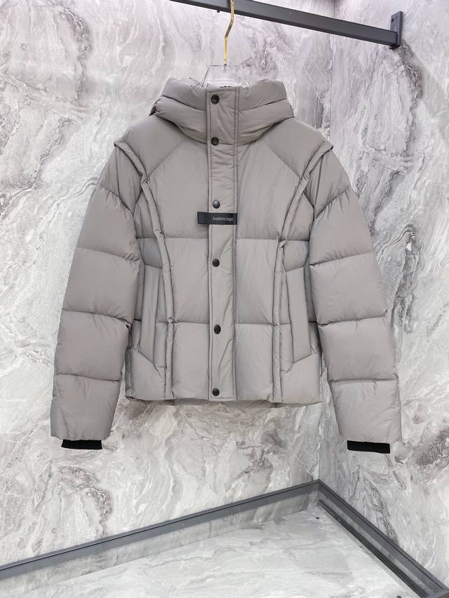 Balenciaga巴黎世家帖饰连帽羽绒服 采用高密哑光聚酰胺面料，质地柔韧抗皱，表面经哑光涂层处理，兼具抗风性与低调质感；保暖锁温的同时保持上身轻盈无负重感；