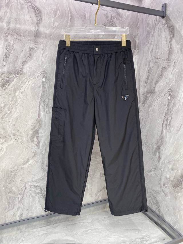 prada 普拉达 25年秋冬新款休闲裤 定制珐琅金属三角形徽标休闲长裤，松紧腰头配抽绳、轻盈有垂感，一年四季都能搭配上的必买款！ 颜色：黑色 码数：48-56