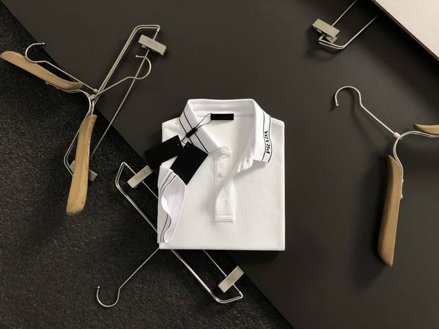 prad**正码正牌S-Xl 2026春夏短袖，以重工领口精工刺绣为主调，巧妙融Y领口提线元素，打破传统短袖的单调感，彰显个性与不羁。立体剪裁贴合身形，设计利落