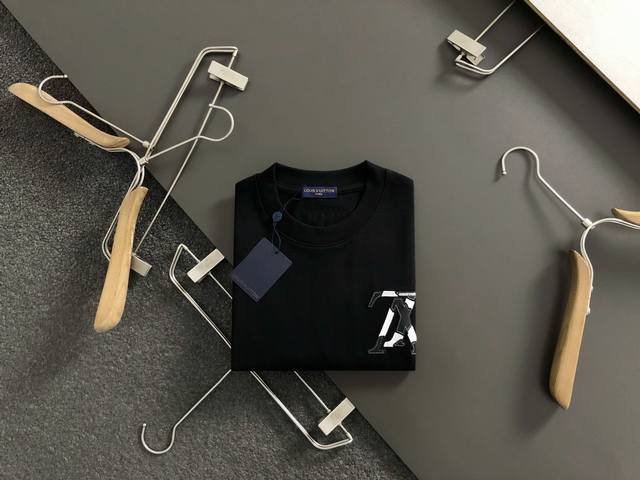 L牌**正码正牌S-Xl 2026春夏短袖，以黑白贴皮绣为主调，巧妙融入前后幅户型重工Logo元素，打破传统短袖的单调感，彰显个性与不羁。立体剪裁贴合身形，设计