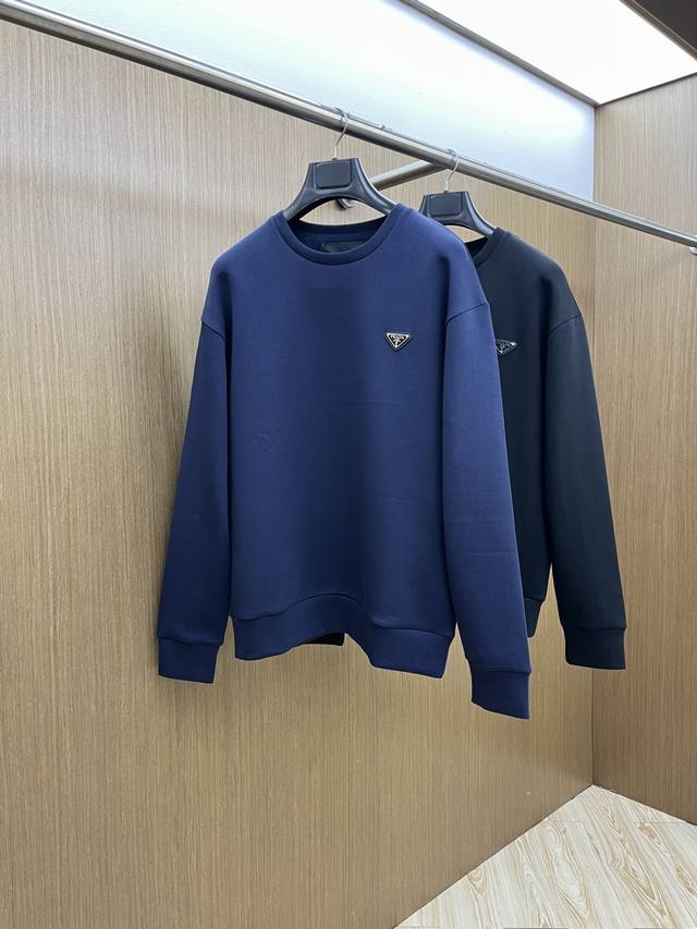 prada普拉达2025 黑标卫衣，是低调质感里的“小心机” 基础款式+极简廓形，适配日常所有穿搭场景，通勤配西裤利落、休闲搭牛仔松弛。胸口标志性三角标是点睛之